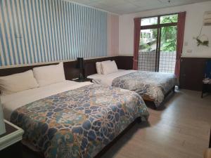 溫泉村的住宿－雷姐的家知本溫泉，酒店客房设有两张床和窗户。
