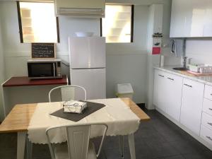a kitchen with a table with chairs and a microwave at Studio Apartment with Seaview in Airlie Beach
