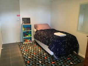 1 dormitorio con 1 cama y suelo de baldosa en Studio Apartment with Seaview, en Airlie Beach