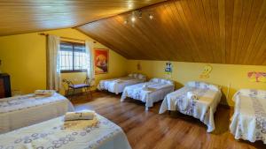 a room with three beds and a wooden ceiling at Casa Las Lomas de San Rafael Periana by Ruralidays in Periana