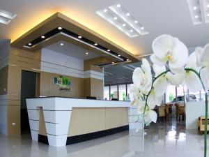 a lobby with a reception desk and white flowers at The Villa Chiangrai in Chiang Rai