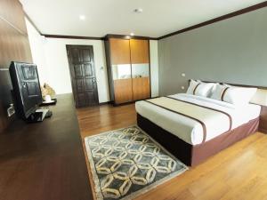 1 dormitorio con 1 cama grande y TV en The Villa Chiangrai, en Chiang Rai