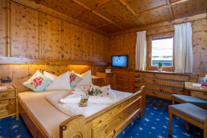 sypialnia z łóżkiem w drewnianym pokoju w obiekcie Hotel Metzgerwirt w mieście Fieberbrunn