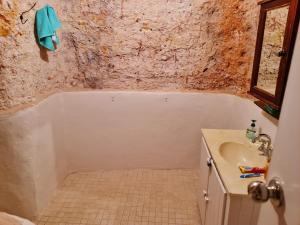 a bathroom with a sink and a bath tub at Underwood Court fresh Dugout- Hosted by Coober Pedy Accommodations in Coober Pedy