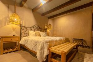 - une chambre avec un lit et un banc dans l'établissement Casa Lavanda Hotel Boutique, à Pátzcuaro