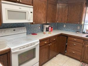 a kitchen with white appliances and wooden cabinets at Irises House - private room in home in Kissimmee