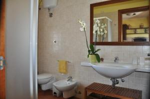 タヴィアーノにあるCorte degli Aranci Casa Vacanzeのバスルーム(洗面台、トイレ、鏡付)