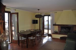 タヴィアーノにあるCorte degli Aranci Casa Vacanzeのダイニングルーム(テーブル、椅子、暖炉付)