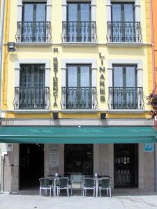 a building with tables and chairs in front of it at Hostal Linares in Ribadeo