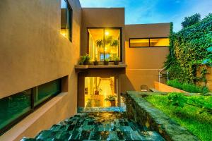 a house with a pond in front of it at Casa Lavanda Hotel Boutique in P&aacute;tzcuaro