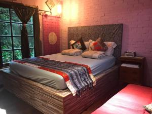 a bedroom with a large bed with a brick wall at A-HOME in Jiufen