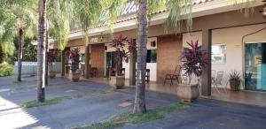 een gebouw met palmbomen ervoor bij Recanto Village Hotel in Cosmorama