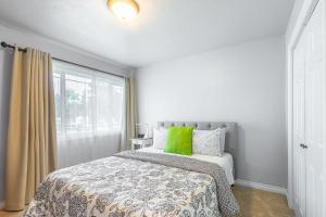 um quarto com uma cama com almofadas verdes e uma janela em Duplex in Alberta Art District em Portland