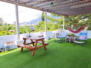 un patio con una mesa de picnic, sillas y una hamaca en 都蘭朋友家 Dulan Friends Hostel, en Donghe