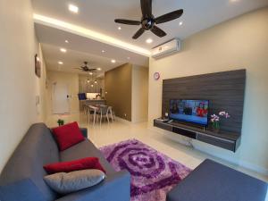 a living room with a couch and a flat screen tv at Southville Stay 2 @ Savanna Executive Suite in Kampong Tangkas