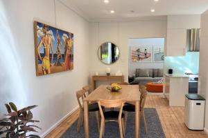 a dining room with a table and a kitchen at The Mitchell Bondi Garden 4 in Sydney