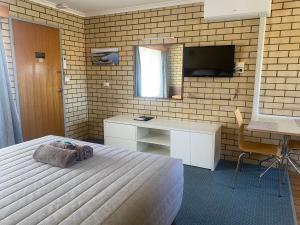 Televízia a/alebo spoločenská miestnosť v ubytovaní Coastal Comfort Motel