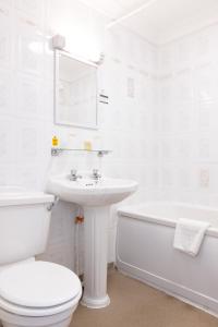 a white bathroom with a toilet and a sink at The Caledonian Tower Hotel in Blackpool