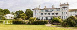 ein großes weißes Haus mit einem Garten davor in der Unterkunft The Imperial Hotel Exmouth in Exmouth