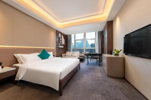 a hotel room with a large bed and a flat screen tv at Honder International Hotel in Guangzhou