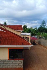 ein Gebäude mit einem roten Dach und einem Innenhof in der Unterkunft The Peak Meadows in Nyeri