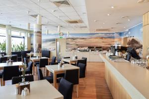 a restaurant with tables and chairs and a counter at Green Park Hotel Klaipeda in Klaipėda