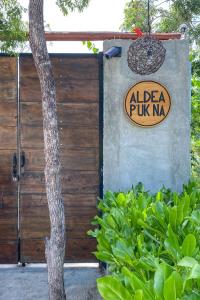 um sinal para um alfa pung na ao lado de uma cerca em aldea pukna em Akumal