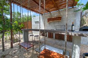 a house with a porch with a swing and a bar at aldea pukna in Akumal