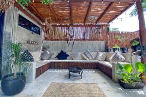 d'un coin salon extérieur avec des plantes et un toit en bois. dans l'établissement aldea pukna, à Akumal
