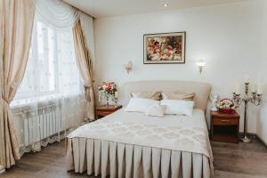 a bedroom with a white bed with a large window at Hotel Lena in Yakutsk