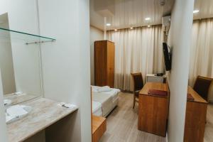a hotel room with a sink and a bedroom at Hotel Lena in Yakutsk