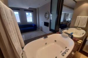 a bathroom with a large tub and a large mirror at Exquisite Apartment with Jaccuzzi Pool Table and Cinema in Johannesburg