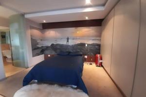a bedroom with a painting of a man in the ocean at Exquisite Apartment with Jaccuzzi Pool Table and Cinema in Johannesburg