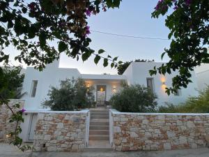 a white house with stairs and a stone wall at Nisides Villa Naoussa in Naousa