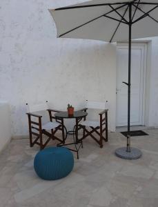 une terrasse avec une table, des chaises et un parasol dans l'établissement Studio in the Centre of Sissi, à Sissi