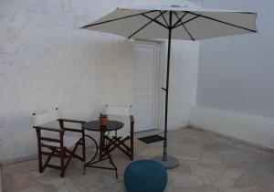 シッシにあるStudio in the Centre of Sissiのテーブルと椅子、傘が備わります。