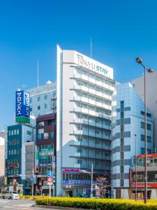 a tall white building with a sign on it at Tokyu Stay Gotanda in Tokyo