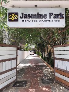 un panneau indiquant le parc jassmine avec une voiture descendant dans une rue dans l'établissement Jasmine park, à Chennai