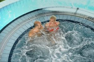 dos niños están jugando en una piscina en Sanatorija ,,Tulpės", en Birštonas