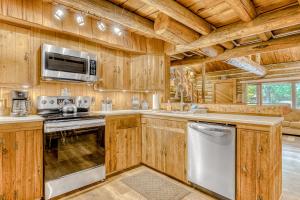 a kitchen with wooden cabinets and a stove and microwave at Best Log Cabin in Brightwood