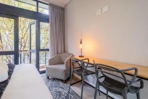a bedroom with a bed and a desk and a chair at Lemon Rind - 16 Eikehoff in Stellenbosch
