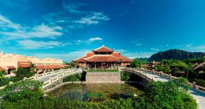 een resort met een vijver voor een gebouw bij Emeralda Resort Ninh Binh in Ninh Binh