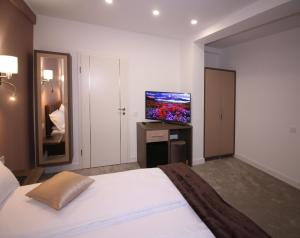 a bedroom with a bed and a flat screen tv at The Butterfly in Sângeorgiu de Mureș