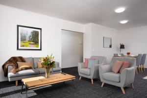 uma sala de estar com um sofá e duas cadeiras e uma mesa em Aligned Corporate Residences Kew em Melbourne