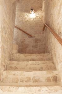 una escalera en un edificio de piedra con una luz en él en Vico Monte II - Casa Vacanze, en Ceglie Messapica