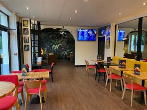 un restaurant avec des tables en bois et des chaises rouges dans l'établissement Le Sporting, au Mans