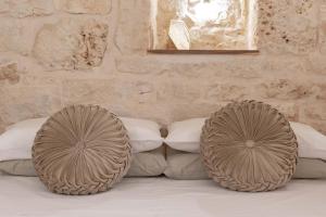 - un lit avec des oreillers blancs et 2 grandes roues dans l'établissement Vico Monte II - Casa Vacanze, à Ceglie Messapica