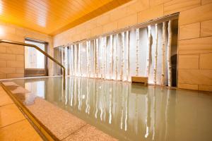 松本Tabino Hotel lit Matsumoto Milky white Onsen的一座带喷泉的建筑中的游泳池