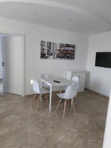 una sala da pranzo con tavolo e sedie bianchi di Stella Guesthouse a Sapareva Banya