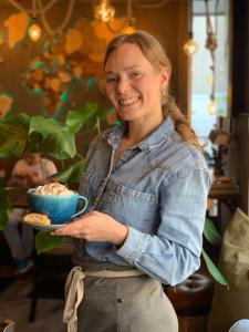 een vrouw houdt een blauwe kom eten vast bij Havshotellet in Malmö